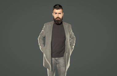 Gri arka planda sakallı, hırslı bir adam..