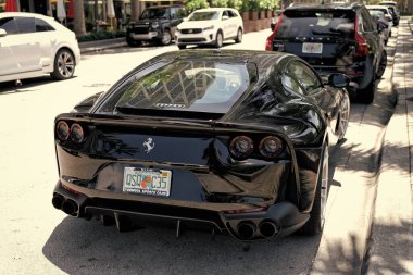 Miami Beach, Florida USA - April 15, 2021: black ferrari F12 berlinetta supercar, side back view.
