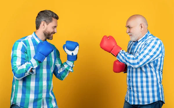 スタジオでの幸せな世代の男性ボクシング 世代の男性ボクシングを背景に 世代の男性ボクシングのチェッカーシャツの写真 黄色に隔離された2世代の男性ボクシング — ストック写真