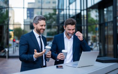 Serbest çalışanların açık havada işleri var. Serbest çalışanların dizüstü bilgisayarla işleri olur. Serbest çalışanların fotoğraflarının internette işi var. İki serbest çalışan adamın internette işi var..