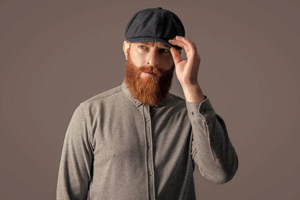 キャップスタジオを調整する深刻なアイルランド人男性 髭の男の肖像画 灰色に隔離された赤い髭を持つUnshaven男 — ストック写真