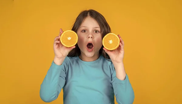 Amazed Teen Girl Holding Orange Fruit Yellow Background — Φωτογραφία Αρχείου
