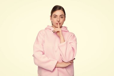 Pembe kapüşonlu genç kız beyaz arka planda izole edilmiş. Sessiz ol..