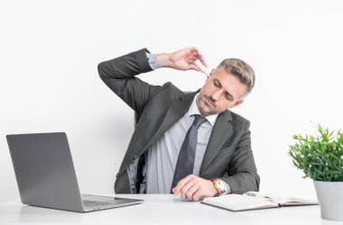 mature man in business office use ear drops.