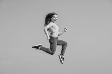 Mutlu genç kız gökyüzü geçmişinde yükseğe zıplıyor. motivasyon.