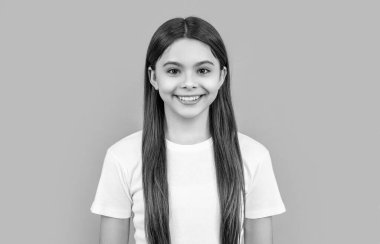 Genç kız Griler 'de izole edilmiş. Stüdyodaki genç kız. Arka plandaki genç kız. Uzun saçlı, tişörtlü genç bir kızın fotoğrafı..