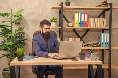 ciddi bir girişimci ofiste bilgisayar ve iş dünyasında çalışıyor..