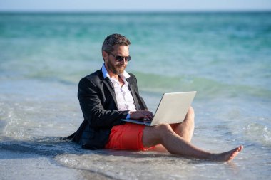 Yaz işi. Yaz tatilinde serbest çalışan bir iş adamı. Hafta sonu ve uzak serbest çalışma. Bilgisayarlı bir iş adamı. İş adamı yazları denizde rüya görür. Yaz rüyaları.