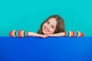 Boş mavi kağıdın arkasında reklam için fotokopi alanı olan mutlu çocuk.