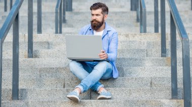 Adamın dizüstü bilgisayarında bilgisayar bağlantısı var. Adamın dışarıda online video iletişimi var. Adamın dışarıda çevrimiçi video bağlantısı var. Adamın merdivenlerde online video bağlantısı var..