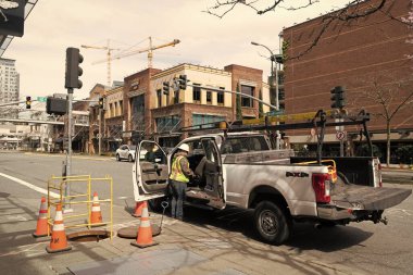 Seattle, Washington, ABD - 2 Nisan 2021: Ford şehir servis arabası kanalizasyonda üniformalı bir adamla.