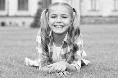 Mutlu çocuk portresi Yeşil çimlerin üzerinde rahatla.