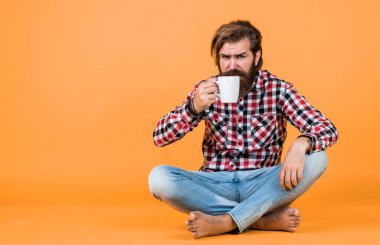 Bardakla içecek. Çay ya da kahve içmek. Günaydın. Evde sabah havası var. İlham konsepti. Hipster adam kahve içer. Beyaz bardak tutan yakışıklı sakallı adam. Boşluğu kopyala.