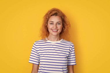 Sarı arka planda izole edilmiş kızıl saçlı kız portresi. Stüdyodaki genç kızıl saçlı kızın portresi. Yetişkin kızıl kız portresi.