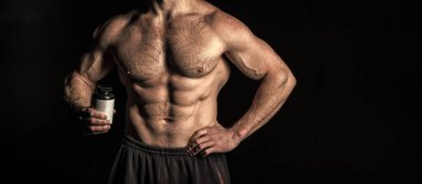 Steroidli kaslı vücut geliştirici, kopyalama alanı. Steroid kavanozlu kaslı vücut geliştirici. Steroid haplı kaslı vücut geliştiricinin fotoğrafı. Siyah steroidli kaslı vücut geliştirici..