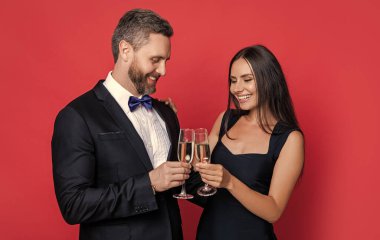 Neşeli çift tezahürat yapıyor ve arka planda kutluyor. Çiftin kutlama fotoğrafı ve şampanyayla kutlama. Çiftler tezahürat yapıyor ve kırmızıda yalnız kutluyorlar. Çiftler tezahürat yapıyor ve stüdyoda kutluyor..