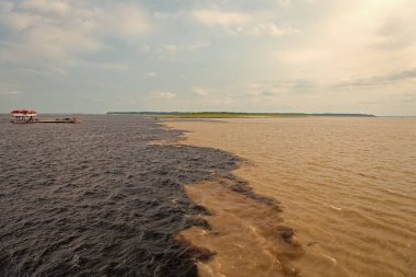 Amazon ve Rio Negro Nehrinin doğal su manzarası. Doğanın sularla buluşan su manzarasının fotoğrafı. Nehrin doğal su manzarası. Seyahat yeri olarak doğa su manzarası.