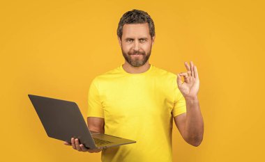 Stüdyodaki adam programcı, tamam. Dizüstü bilgisayarlı adam programcısının fotoğrafı. İnsan programcısı sarıda izole edildi. Arka plandaki adam programcısı.
