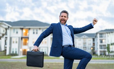 Pozitif emlak işçisi. Evrak çantalı emlakçı. Dışarıdaki emlakçı. Gayrimenkul işçisi fotoğrafı..