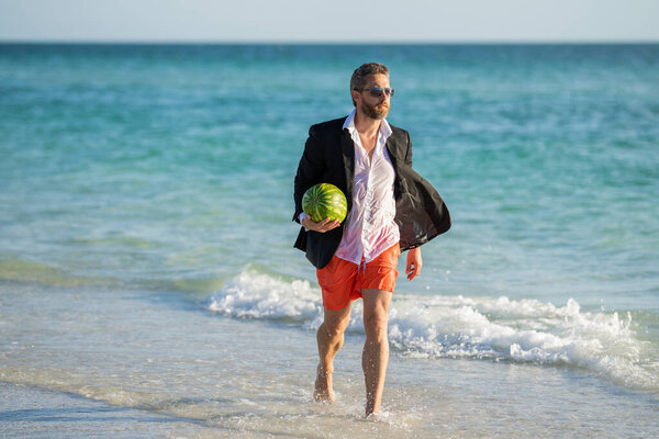 Летние каникулы и туристическая концепция. бизнесмен на пляже. Бизнесмен с арбузом. Летние каникулы. Успешный бизнесмен в отпуске. Горячий летний бизнес. Бизнес и солнце.