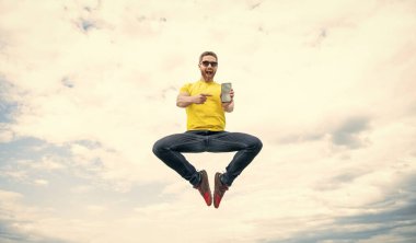 Şaşırmış bir adam zıplıyor ve gökyüzünde akıllı telefon sunuyor..