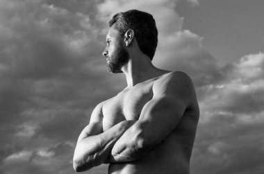 shirtless muscular man. strong man with muscular torso. athletic man on sky background.