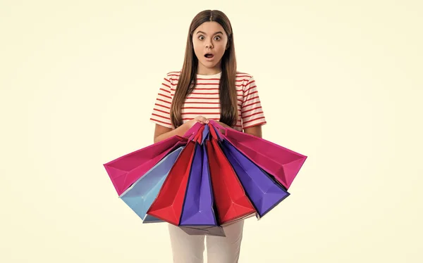 震惊的购物狂女孩拿着购物袋在工作室里 一个购物狂的女孩去购物 购物狂女孩购物后的照片 带有白色背景的购物袋的少女购物狂 — 图库照片