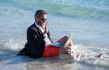 Yaz haftasonu ve uzak bağımsız çalışma. Bilgisayarlı bir iş adamı. İş adamı yazları denizde rüya görür. Yaz işi. Yaz tatilinde serbest çalışan bir iş adamı. Yenilenmek için seyahat.