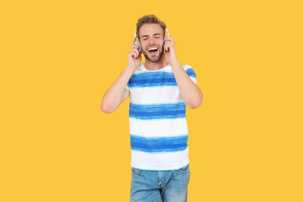 Glad Man Uses His Headphones Listen Music Isolated Yellow Background — Stock Photo, Image