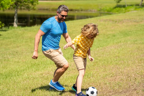 football family team of father and son. soccer activity. Fatherhood in outdoor of daddy and son kid. daddy with son improve fatherhood. Outdoor adventures of daddy and son fatherhood together.