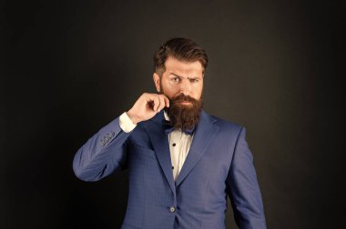 Smokin papyonlu ciddi bir adamın bıyığı var. Siyah arka planda resmi giyinmiş bir beyefendi. erkek resmi moda.