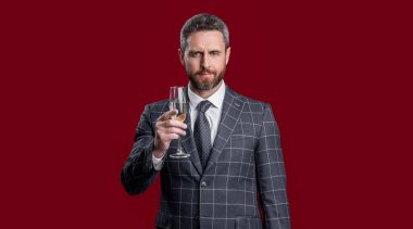 Tezahürat yapan ve kırmızı arka planda izole edilmiş bir adamı kutlayan. Adam olayı kutluyor ve tezahürat yapıyor. Adam kutlamak için şampanyayla tezahürat yapıyor. Adam stüdyoda tezahürat yapıyor ve kutluyor..