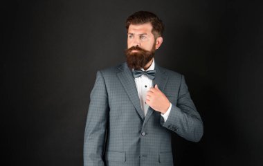 Mavi smokinli ciddi bir adam. Önüne bak. Siyah arka planda resmi giyinen garson. Erkek resmi moda. Boşluğu kopyala.
