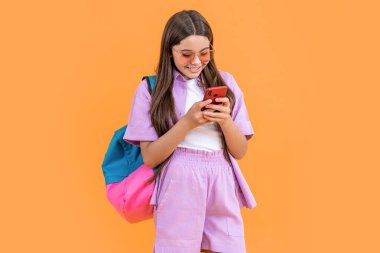 Genç kız sohbeti sarı renkte izole edilmiş. Stüdyoda liseli kız sohbeti. Genç kız sohbetleri arka planda. Liseli kızların telefonla sohbet ederken çekilmiş bir fotoğrafı..