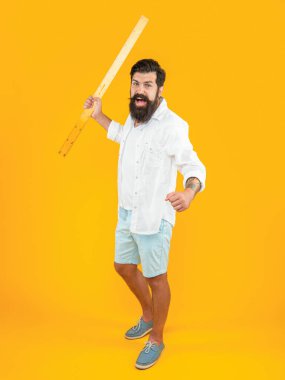 Cetveli kızgın adam sarıda izole edilmiş. Stüdyoda ölçücü cetveli olan adam. Arka planda cetveli olan adam. Ölçü cetvelli bir adamın fotoğrafı.