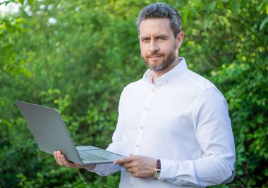 Neşeli iş adamının dışarıda online işi var. İş adamının bilgisayarında internet işi var. İş adamının fotoğrafının internette işi var. İş adamının internet işi var.