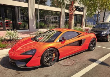 Los Angeles, Kaliforniya ABD - 24 Mart 2021: Turuncu McLaren Otomotiv Limited 570 'ler lüks spor araba yan görünümü.