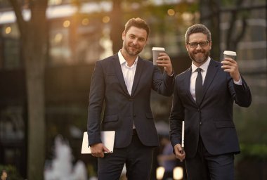 Yönetici dışarıda iş konuşuyor, fotokopi odası. Takım elbiseli bir yönetici kahve içerken iş konuşuyor. Yöneticinin kahve içerken çekilmiş bir fotoğrafı. Yönetici sokakta iş konuşuyor.