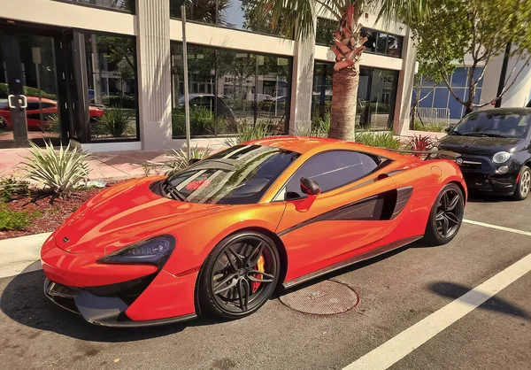 Los Angeles, Kaliforniya ABD - 24 Mart 2021: Turuncu McLaren Otomotiv Limited 570 'ler lüks spor araba yan görünümü.