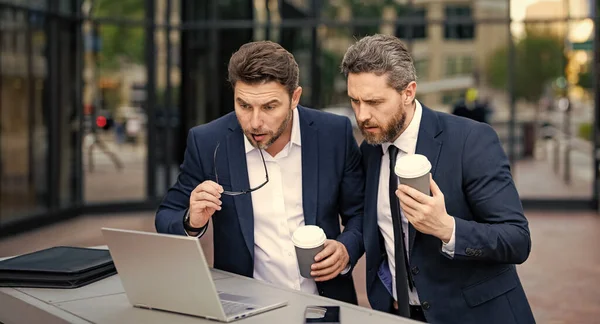 stock image freelancer men have business online outdoor. freelancer men have business online with laptop. photo of freelancer men have business online. two freelancer men have business online.