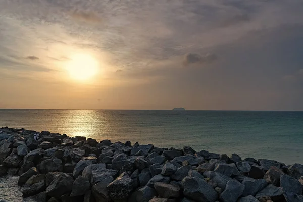 Yaz mevsimi deniz manzarası, gün doğumunda kayalarla birlikte. Güneş doğarken deniz manzarası. Güneş doğarken deniz manzarasının fotoğrafı. Deniz manzarası güneş doğarken.