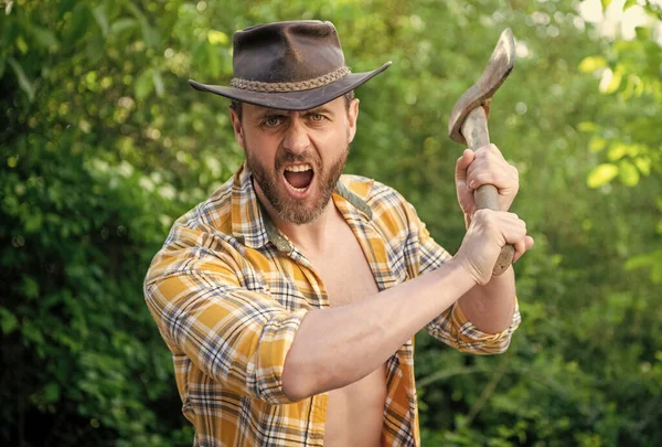 stock image angry lumberjack shout with axe outdoor. photo of angry lumberjack with axe. angry lumberjack with axe. angry lumberjack with axe wearing checkered shirt.