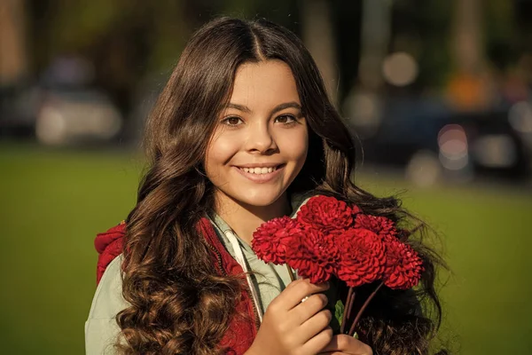 stock image positive teen girl with autumn bouquet outside. photo of teen girl with autumn bouquet. teen girl with autumn bouquet outdoor. teen girl with autumn flowers bouquet.