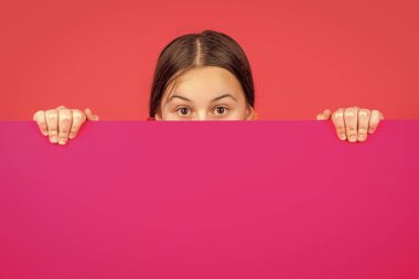 Reklam için fotokopi alanı olan boş pembe kağıdın arkasında genç bir çocuk..