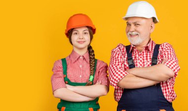 Sarı arka planda kasklı neşeli kız ve büyükbaba müteahhit..