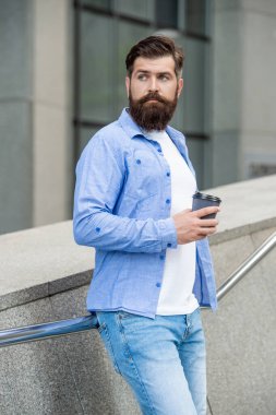 Adam dışarıda kahve içiyor. Dışarıda kahve içen bir adam. Adam sokakta kahve içiyor. Kahve içen bir adamın fotoğrafı..