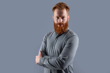 Kendinden emin İrlandalı adam. Sakallı ve bıyıklı adam. Ciddi tıraşsız adam kollarını çapraz tutuyor..