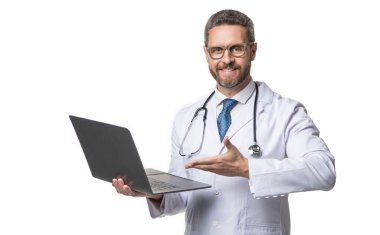 Gülümseyen doktor stüdyoda ilaç öneriyor. Doktor arka planda e-tıp sunumu yapıyor. Elektronik tıp ve dizüstü bilgisayarlı bir doktorun fotoğrafı. Beyazda izole edilmiş e-tıbbı destekleyen doktor.