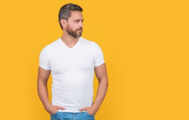 Fotokopi alanı olan sıradan giyinen bir adam. Sarı arka planda izole edilmiş sıradan gömlekli sakallı bir adam. Stüdyoda sıradan bir adam. Beyaz gömlek giyen beyaz bir adamın fotoğrafı..