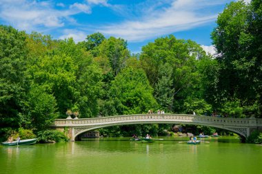 New York, ABD - 22 Temmuz 2023: New York 'ta Manhattan' ın göl ve bina manzaralı Central Park. NYC 'deki resim havuzu.